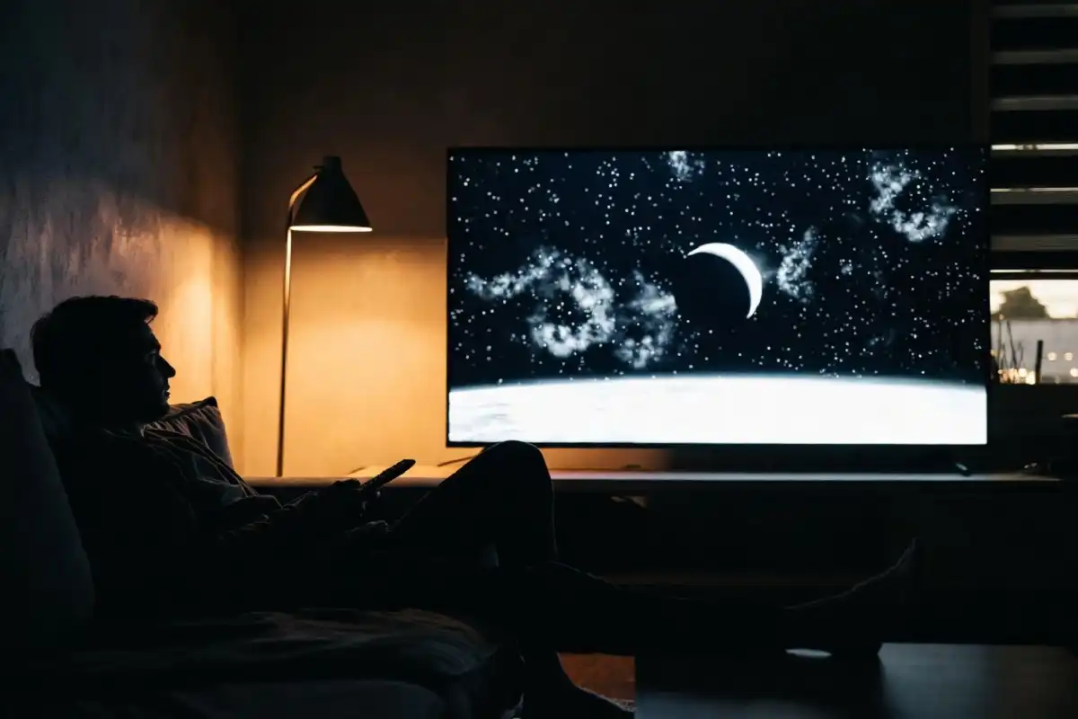 Viewer enjoying classic Roger Ebert sci-fi movies on a home television at night
